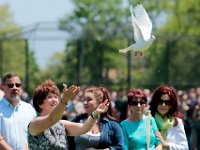 Family looks on as Rosemary Heath releases a dove in memory of her husband George Heath at the Greater New Bedford Regional Vocational Technical High School stadium.   PETER PEREIRA/THE STANDARD-TIMES/SCMG